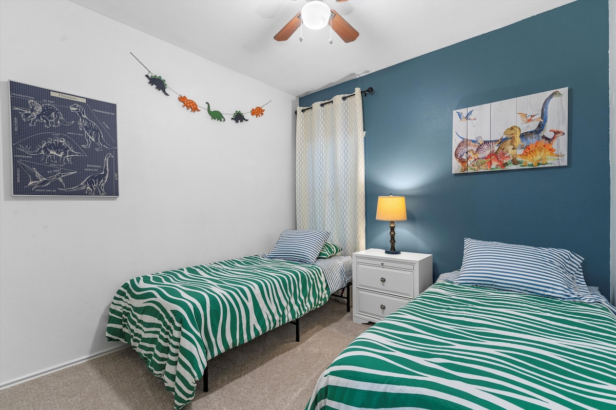 Backyard, Games & Grill bedroom with two twin beds and dinosaur décor