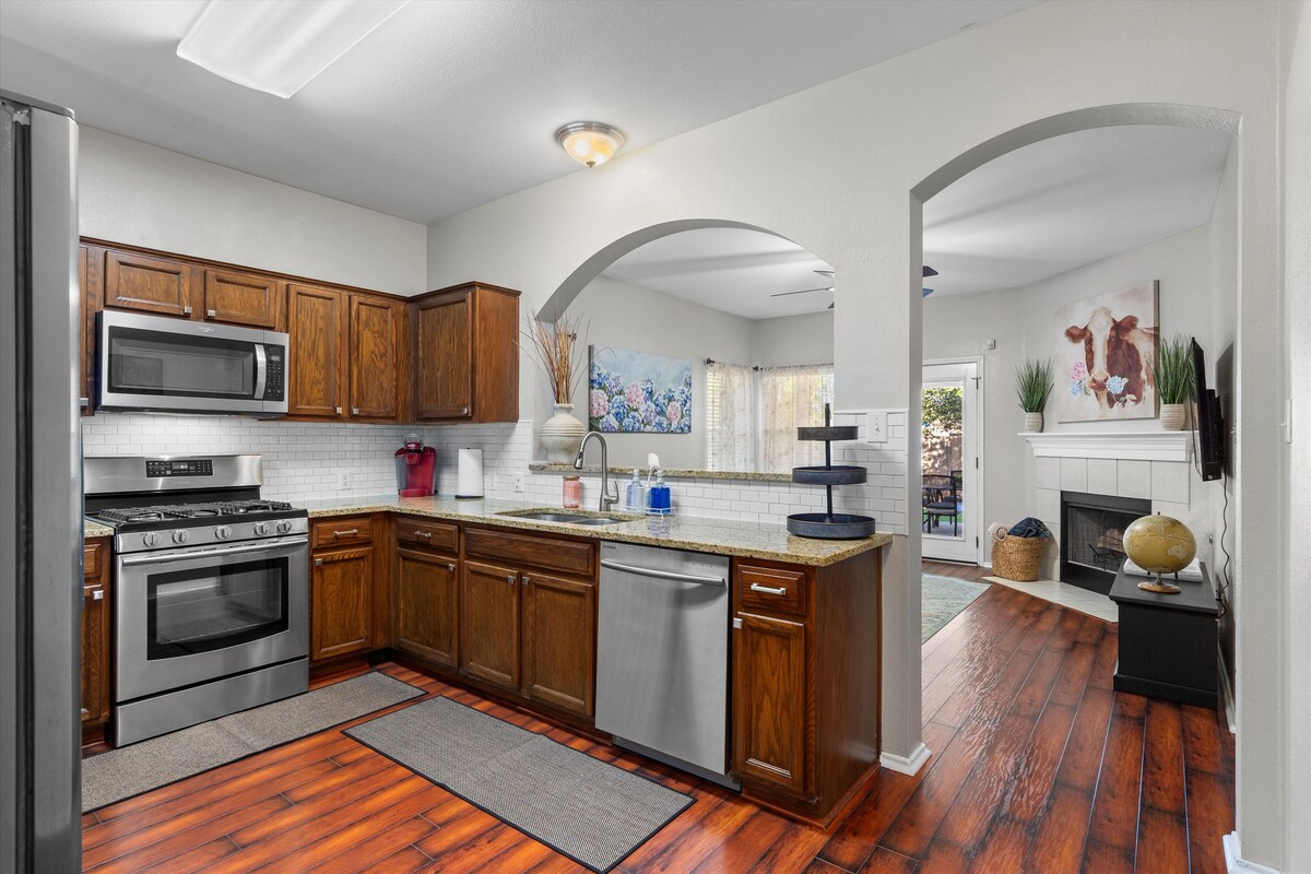 Backyard, Games & Grill kitchen with wood cabinets opening to the living room