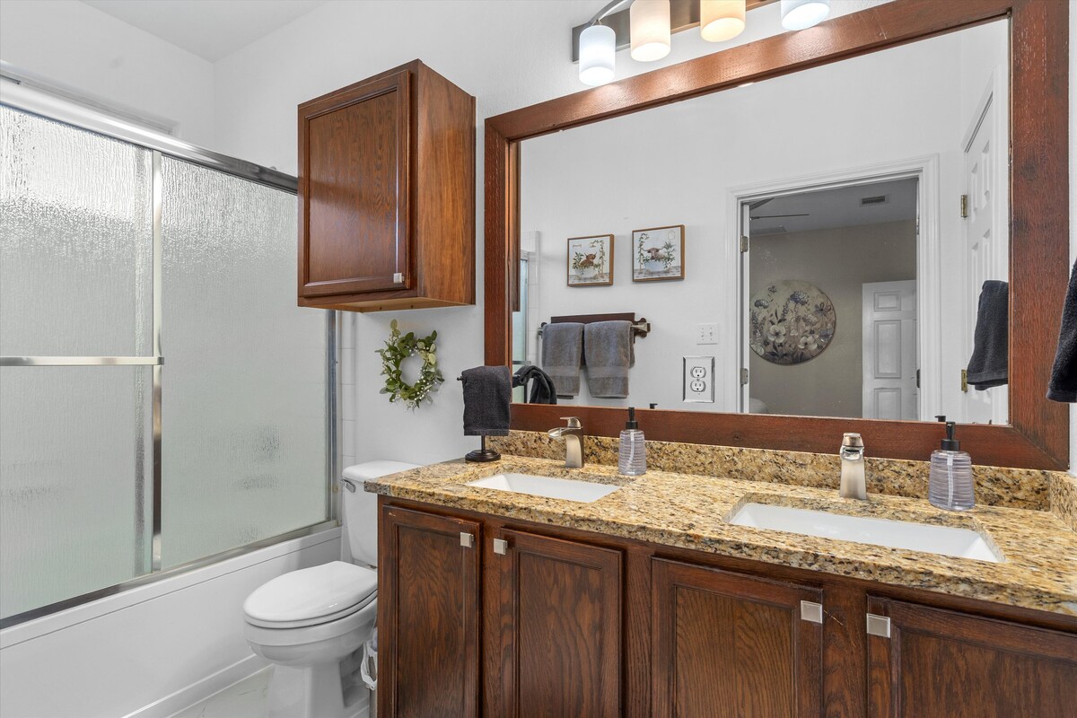 Backyard, Games & Grill bathroom with double vanity and tub shower