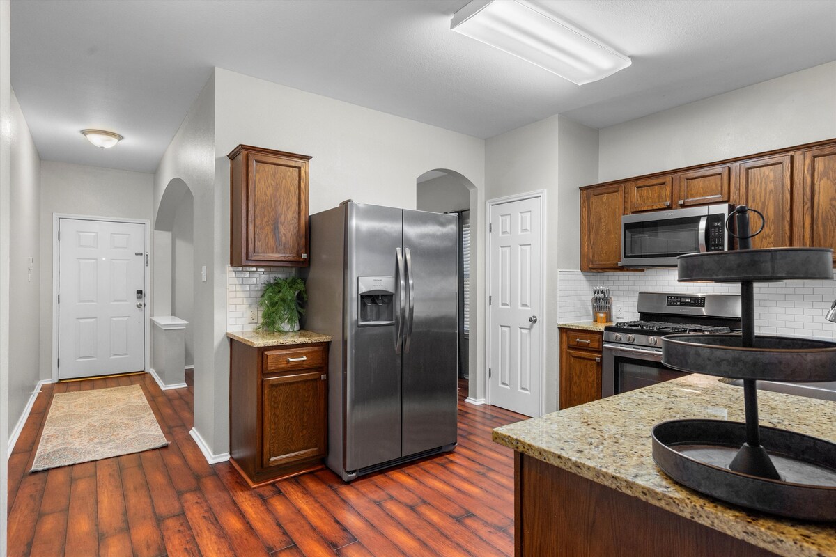 Backyard, Games & Grill kitchen with stainless refrigerator near the entry
